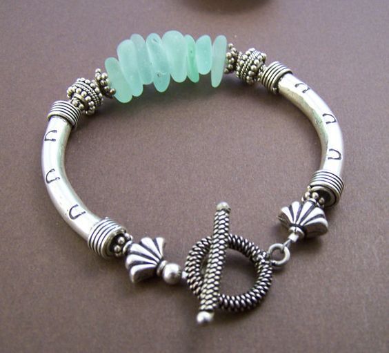 Genuine surf tumbled sea glass bracelet with sterling curved tubes .