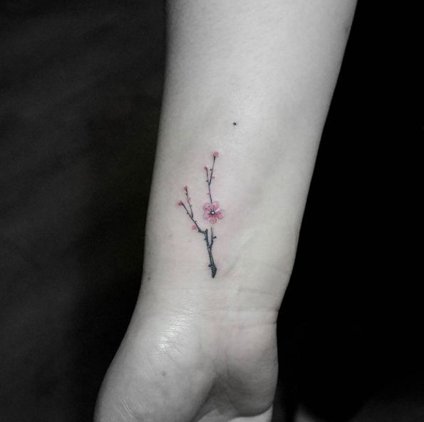 Tiny cherry blossom tattoo on wrist by Tattoo With Me | Tatuajes .