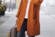 Fall/winter orange coat with blue dark jeans, steet style outfit .