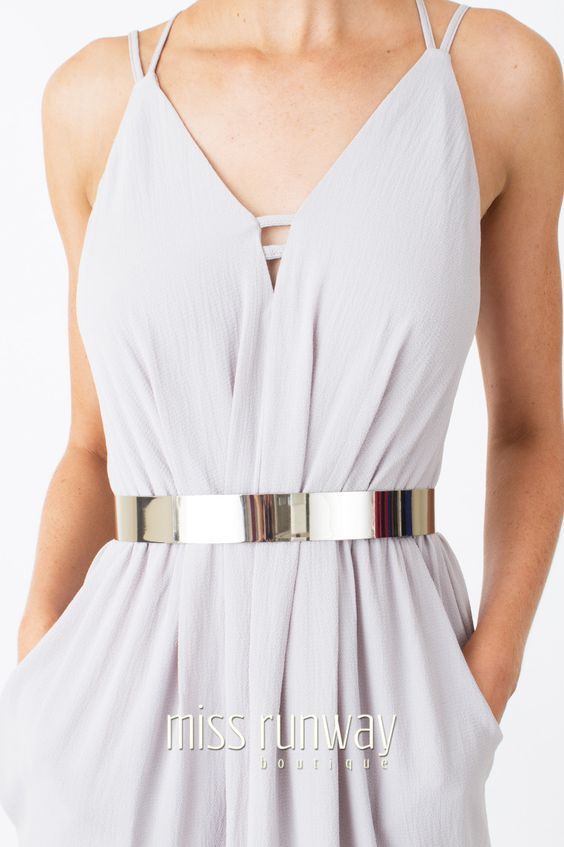 Breezy white strappy dress with silver metal belt cinching waist .
