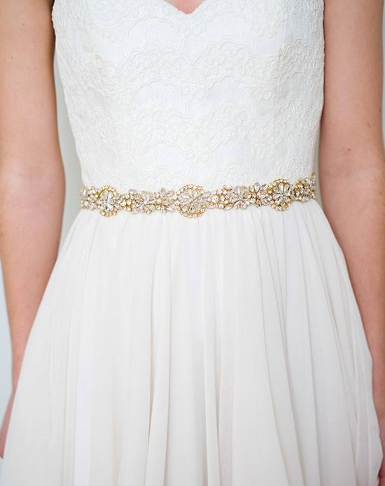 An ornate gold bridal belt featuring radiant rhinestone medallions .