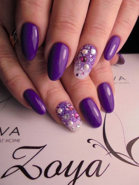 ultra violet manicure with bold accent nails with rhinestones .
